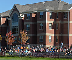 Students in bleachers cheering on a sports team