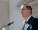 headshot of a man speaking into a microphone