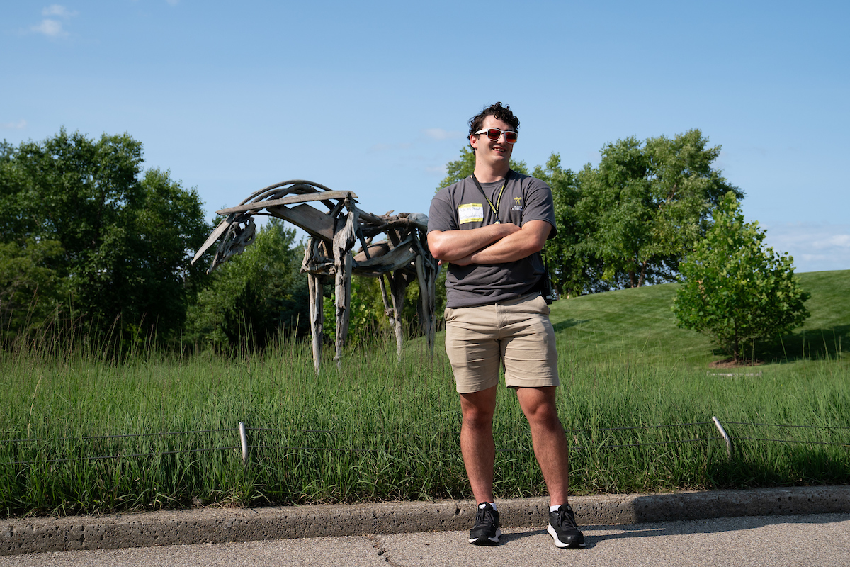 Donnelly in front of a sculpture of a horse made of bronze casted driftwood called Cabin Creek