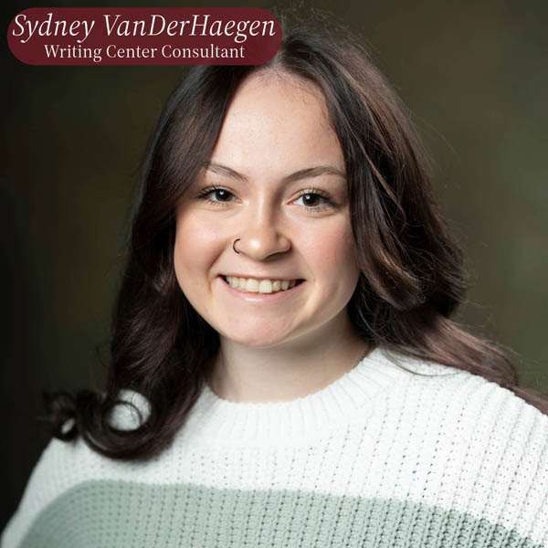 Headshot of a girl with long, dark hair and a nose ring in front of a brown backdrop. Text reading: Sydney VanDerHaegen, Writing Center Consultant.