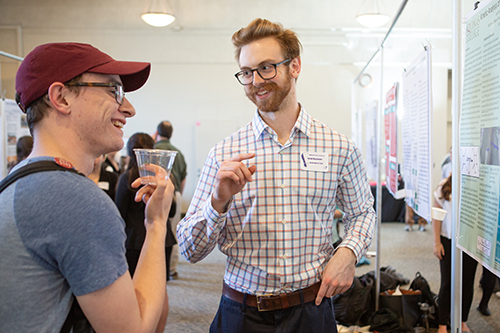 Student and professor talking at poster board