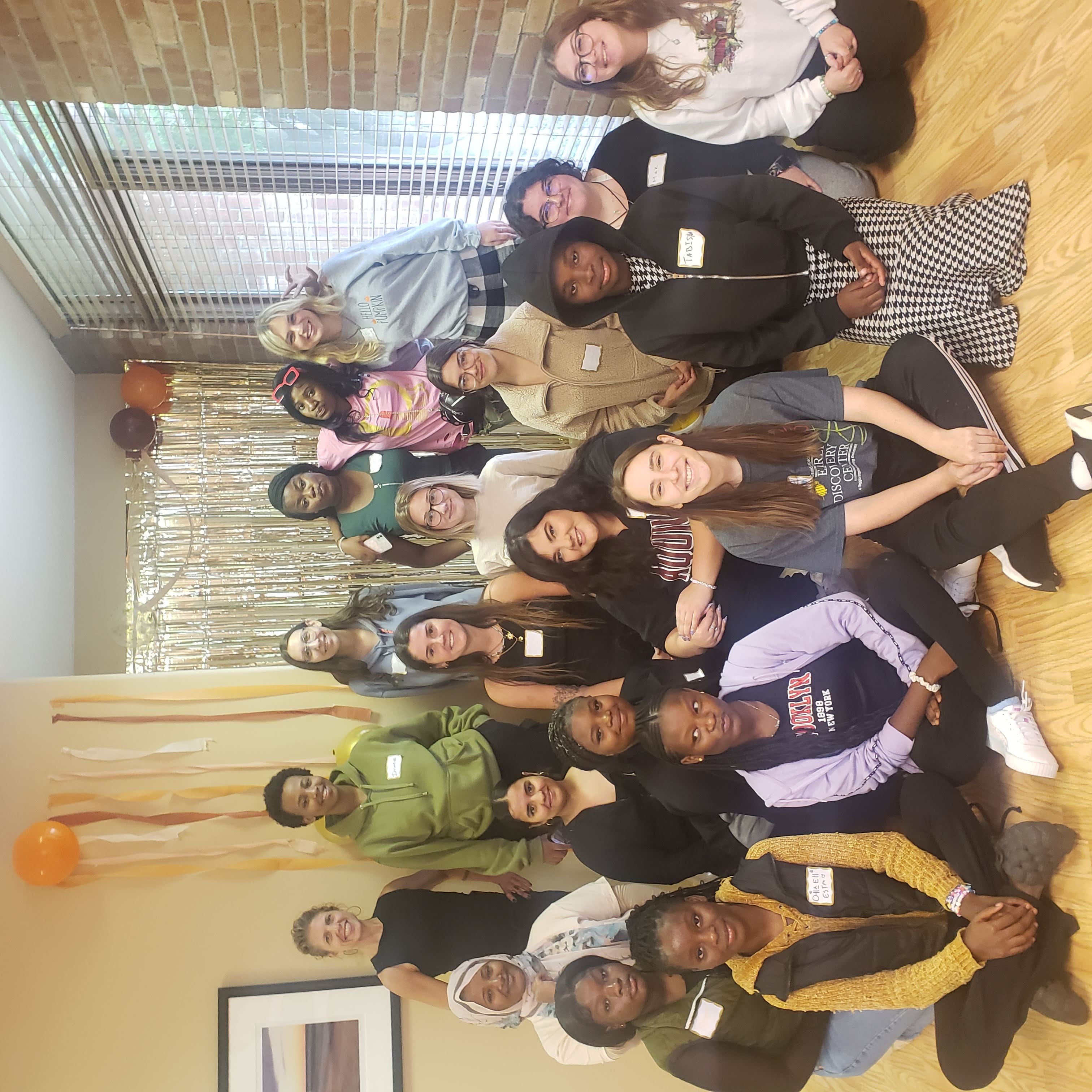 Students and refugee teens pose together at fall celebration